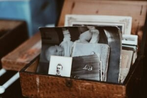 Talc legacy exposure: old family photographs piled inside a wooden chest