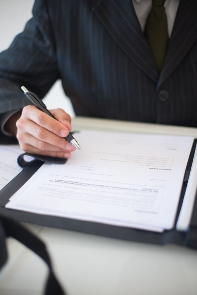 J&J talc settlement: close-up of a hand holding a pen over paperwork