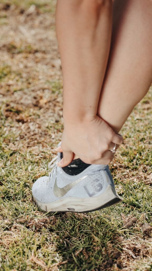 Cartiva implant failure: person holding their foot and ankle in a sneaker, suggesting pain