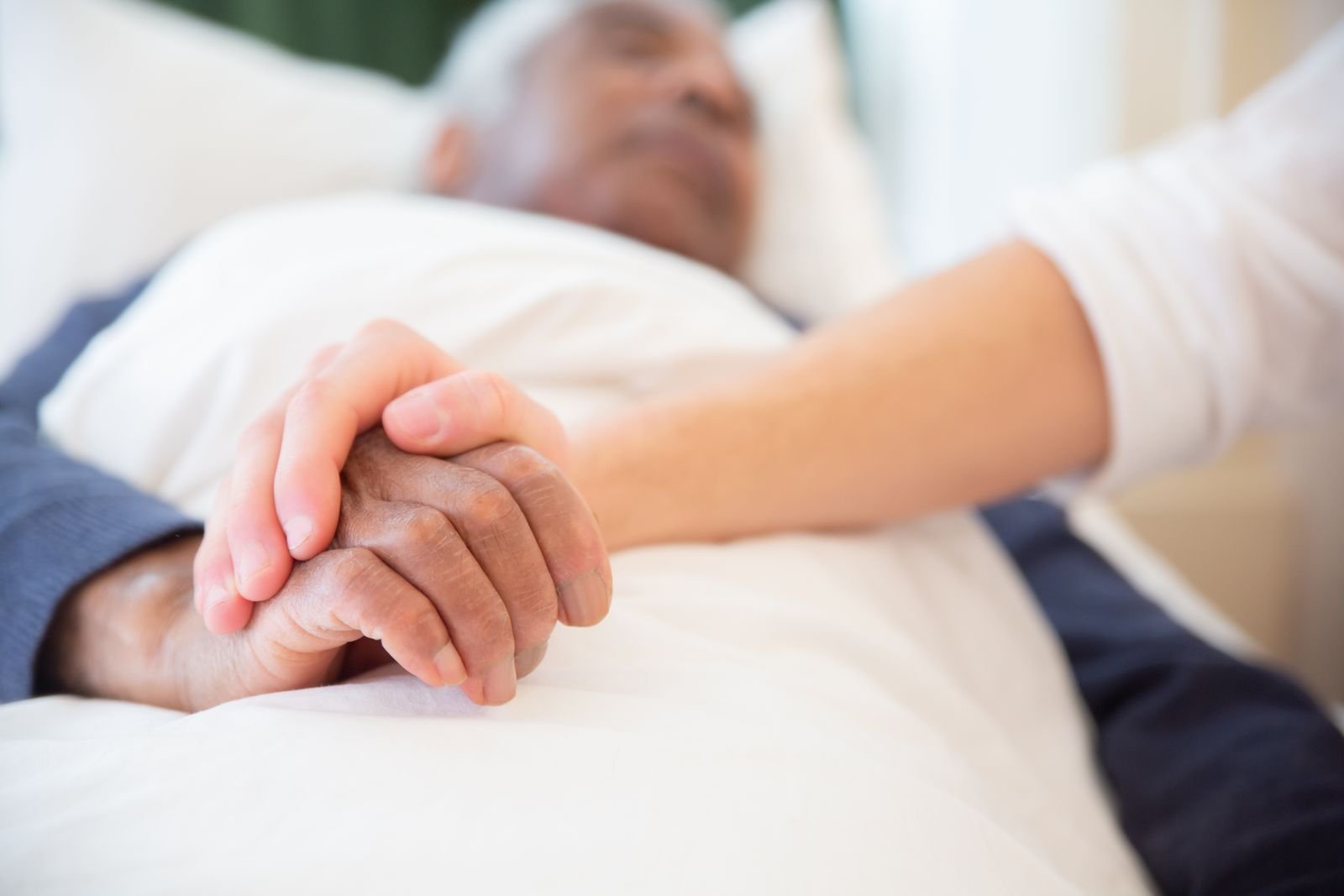 Living with a Bard PowerPort injury: a younger person's hand gently holding an older person's hand