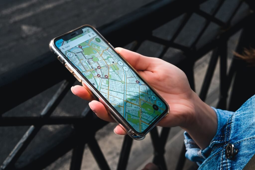 Rideshare safety features: hand holding a smartphone showing a map app on a city street