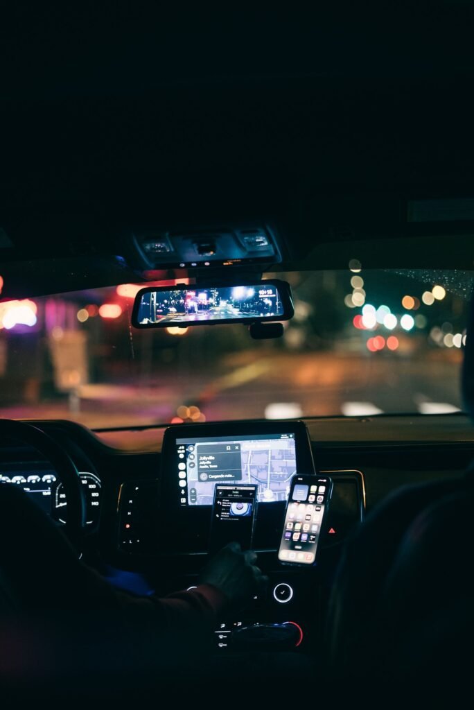Rideshare safety features: car interior at night with a phone showing GPS navigation