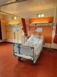 Transvaginal mesh lawsuit: empty hospital room with an adjustable bed and medical equipment