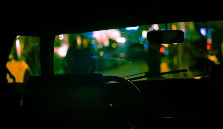 Uber and Lyft lawsuits: view through a car windshield of city lights at night