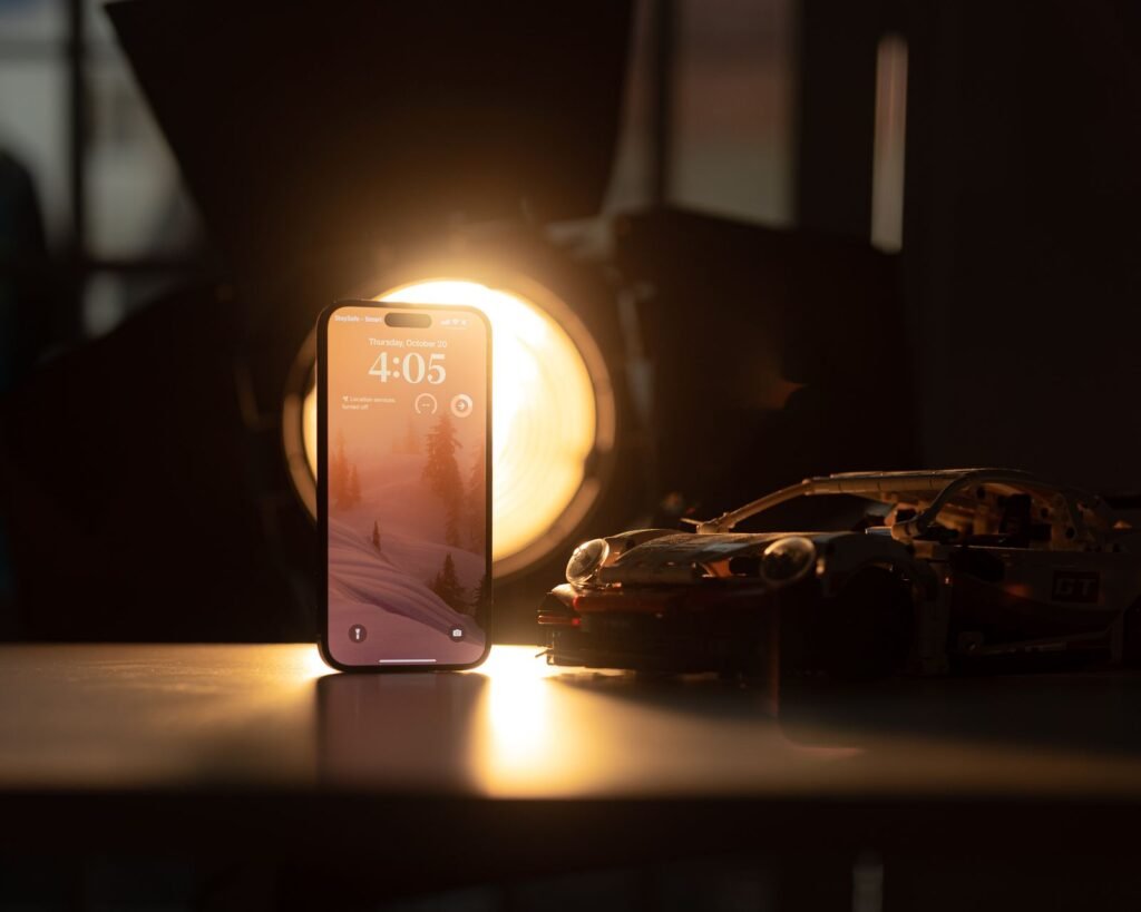 Warning signs a child is targeted online: smartphone on a desk showing a clock app under soft lighting