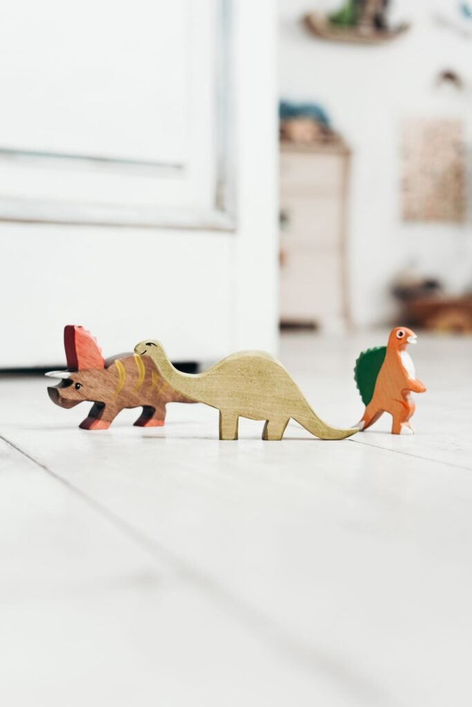 Chlorpyrifos exposure in children: row of colorful wooden dinosaur toys on a playroom floor, no child shown