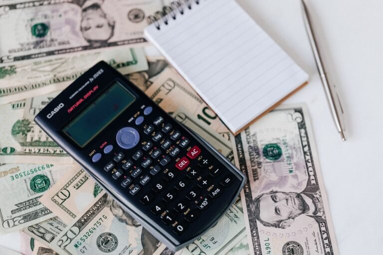 Depo-Provera settlement: calculator, notepad and pen on top of U.S. dollar bills, representing settlement value questions