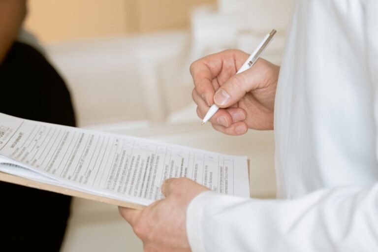 Bard PowerPort claim documents: person in a white coat reviewing patient documents on a clipboard