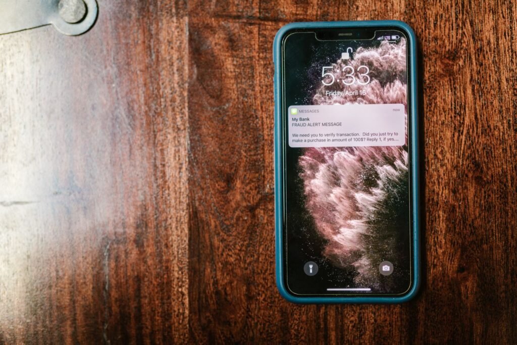 Online exploitation evidence: smartphone lying on a wooden table with an alert on its screen