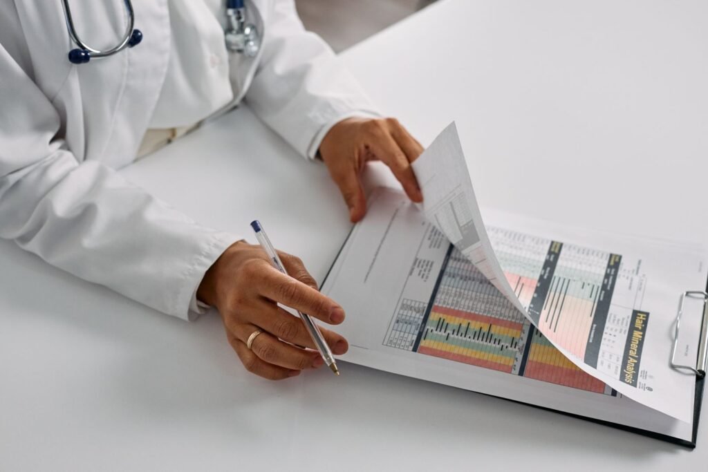 Zantac lawsuits: a clinician's hands holding a notepad and pen while reviewing patient notes