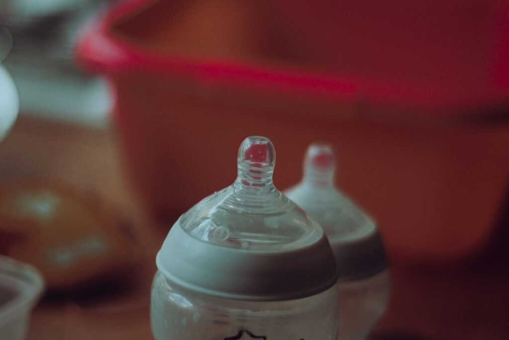 Clear plastic baby feeding bottle on a table, representing feeding questions in an NEC baby formula lawsuit