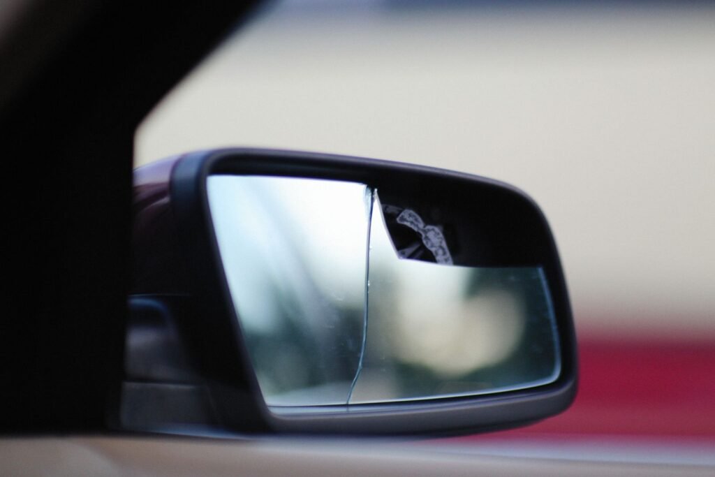Cracked car side mirror after a crash, the kind of damage to photograph for a car accident claim
