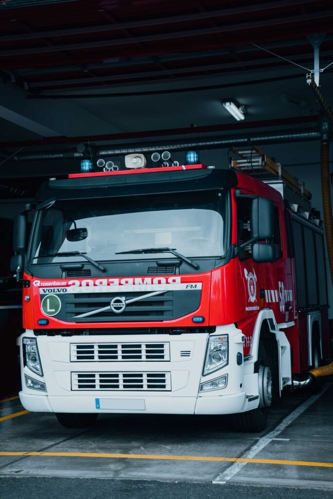 Red fire truck parked inside a fire station garage