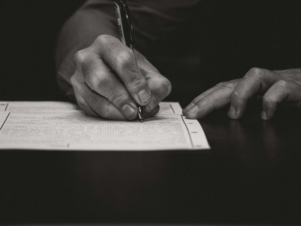 Close-up of a hand writing with a fountain pen on a formal document