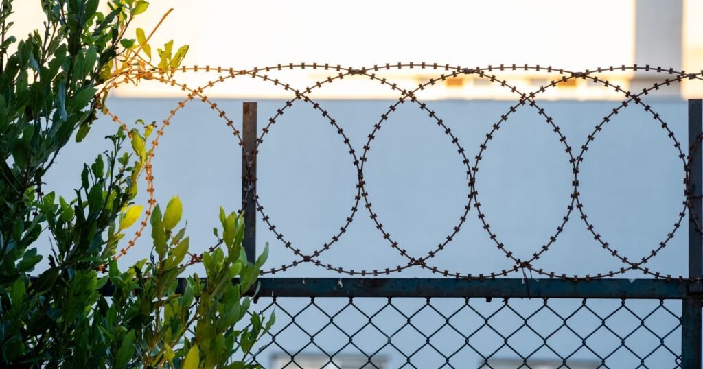Fence topped with wire outside a California women’s prison