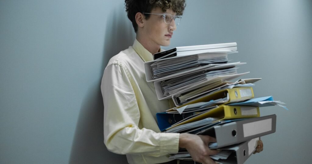 Man holding a large pile of documents, illustrating records and evidence for a CIW abuse lawsuit