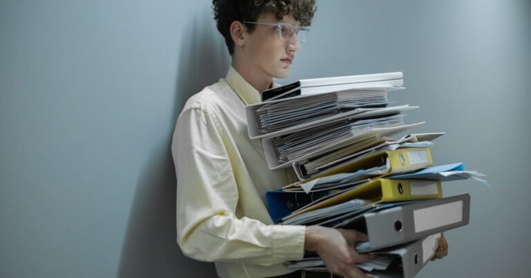 Man holding a large pile of documents, illustrating records and evidence for a CIW abuse lawsuit