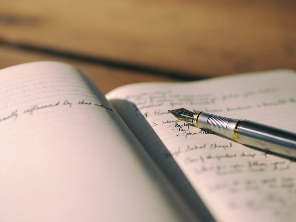 Fountain pen resting on lined journal paper, ready to write down dates and details