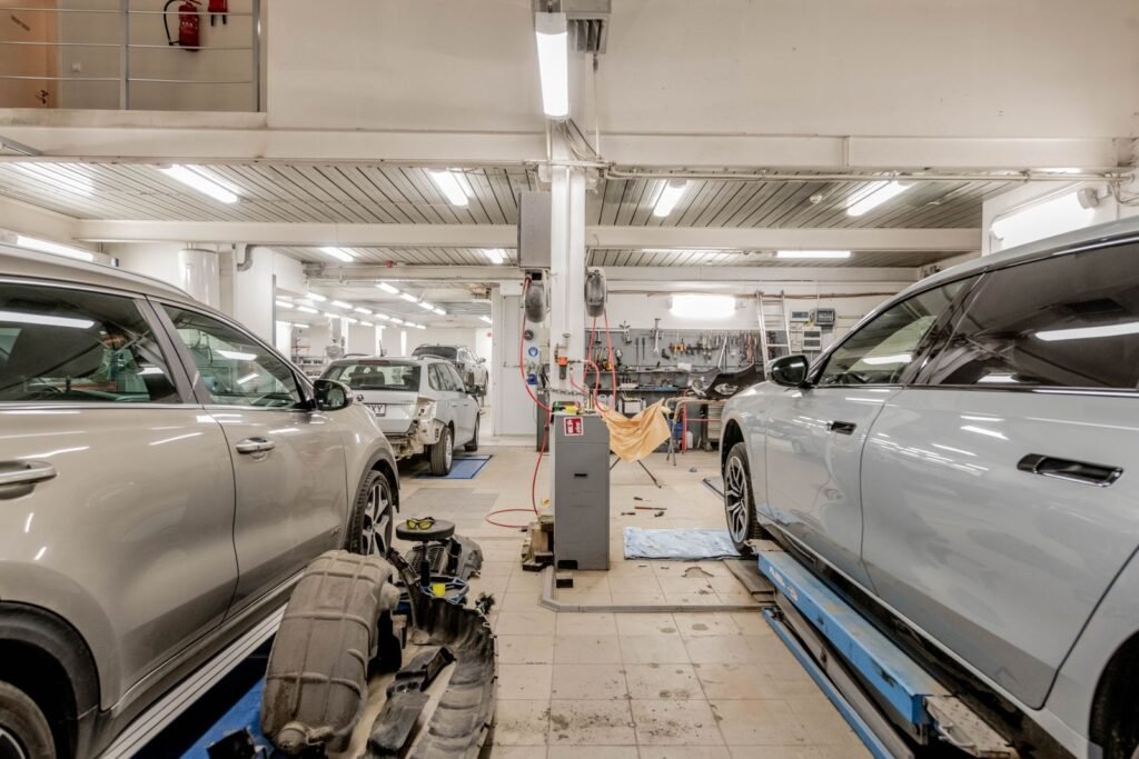 Cars inside an auto repair workshop, where a rideshare driver may face repair costs and time off the road