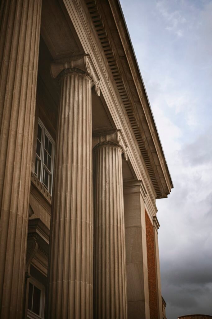 Historic stone building with columns and a clock in a small town