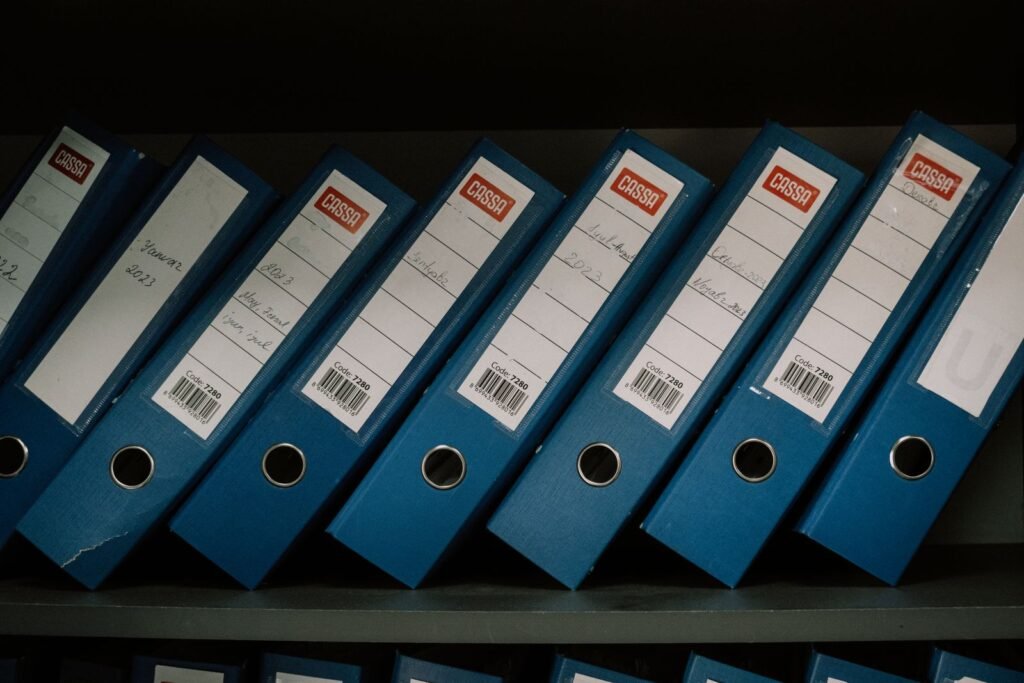 Row of labeled blue office binders on a shelf, showing organized case records