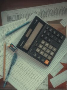 Final expense claim denied: calculator resting on a pile of papers on a desk, representing a final expense claim review
