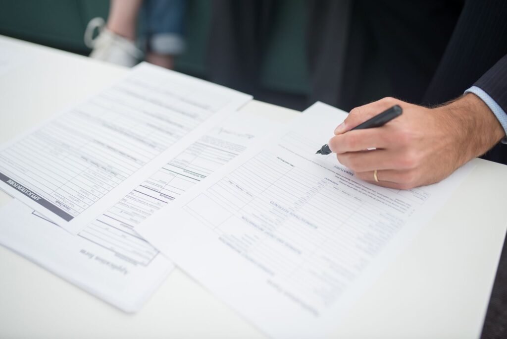 Hand with a pen reviewing insurance papers after a final expense claim denied by the insurer