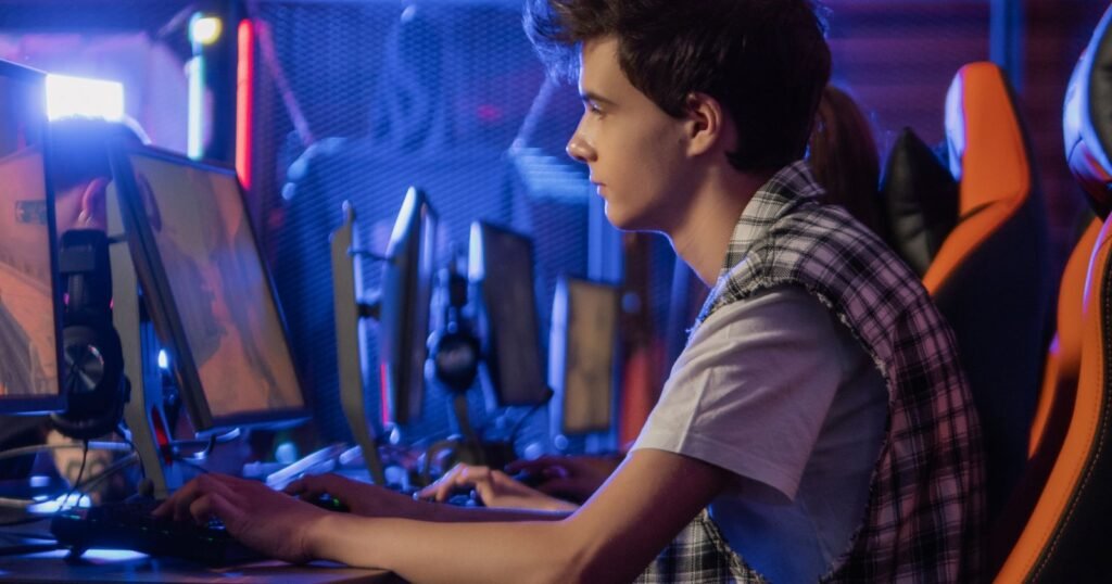 Teenager playing video games at a gaming computer setup, illustrating gaming addiction lawsuit eligibility