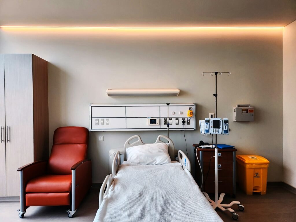 Quiet hospital room with a bed and chair, the kind of setting where uterine cancer care takes place