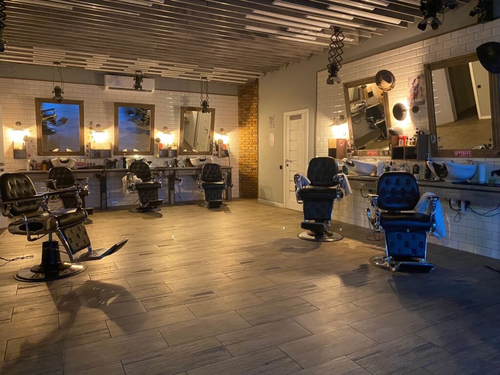 Empty hair salon with styling chairs, mirrors and overhead lighting