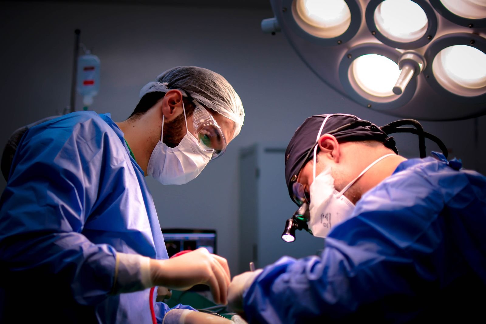 Surgeons performing an operation in a hospital operating room, as in hernia mesh repair surgery