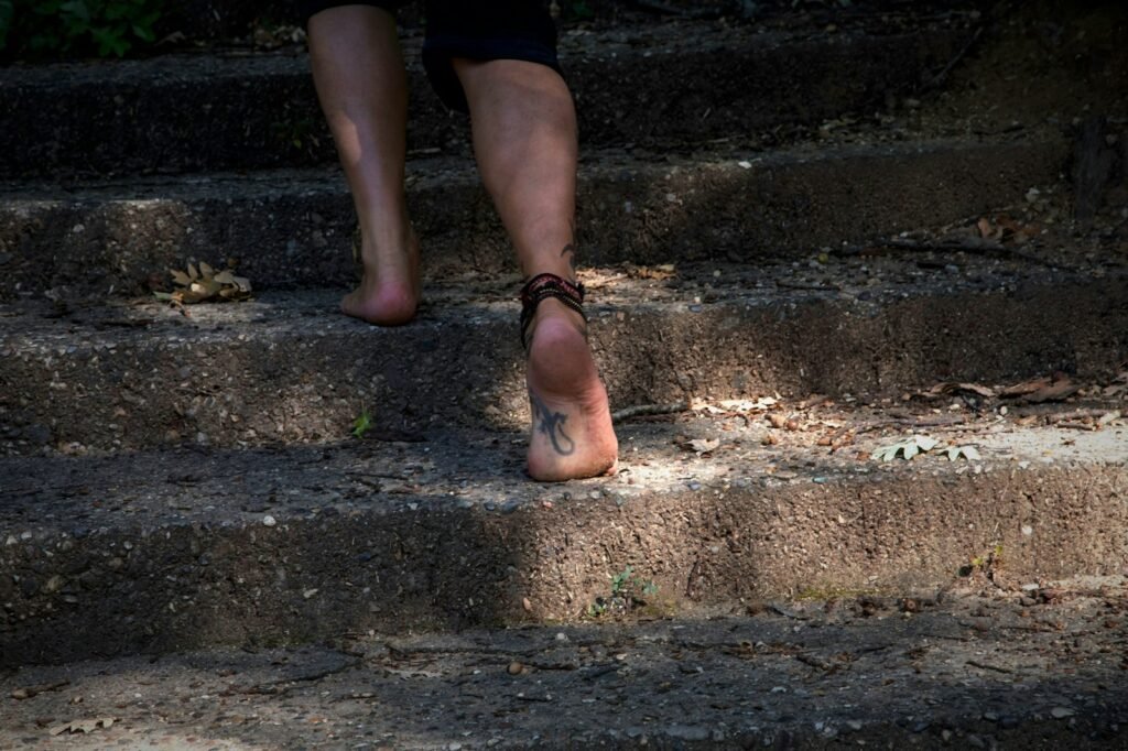 Bare feet climbing outdoor stairs, a daily task that can become hard for Cartiva toe implant patients