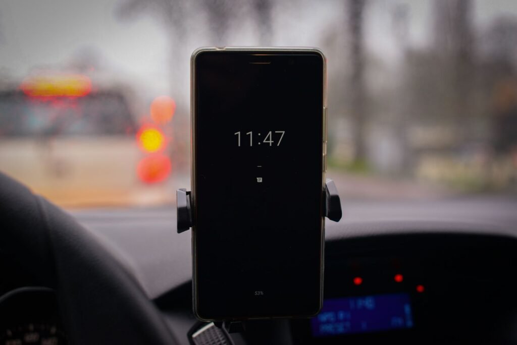 Smartphone mounted in a car with traffic in the background, showing how app status shapes coverage