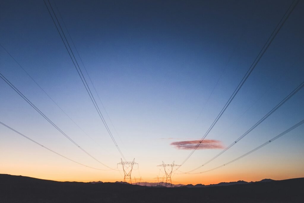 Two electric transmission towers at golden hour, the kind of utility equipment at issue in inverse condemnation