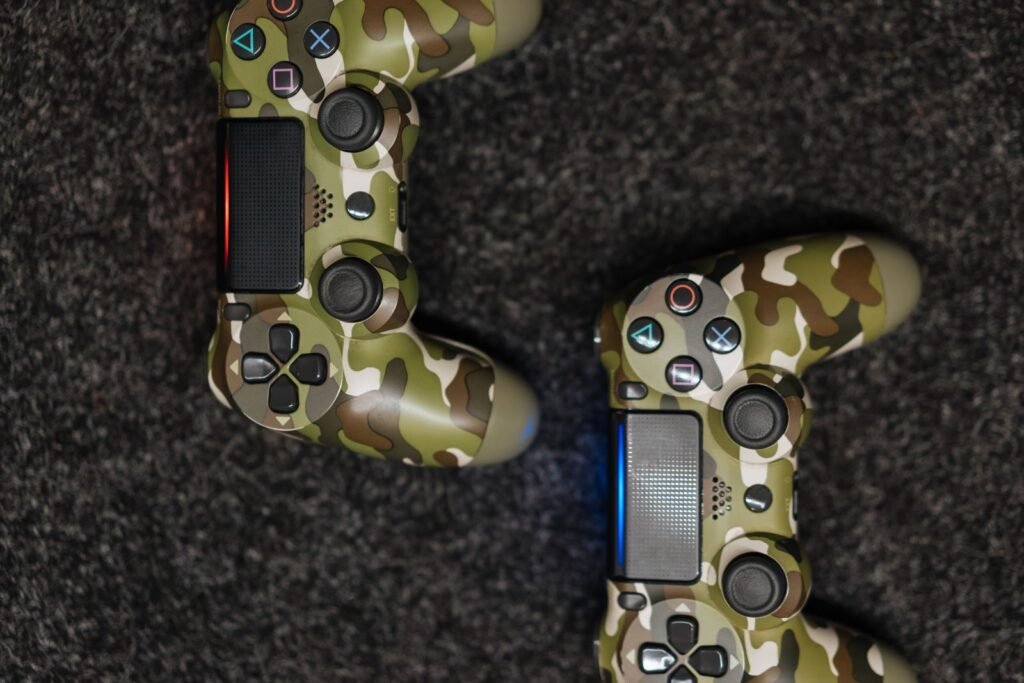 Two camouflage game controllers on a dark carpet, a reminder of how Roblox harm can begin during play
