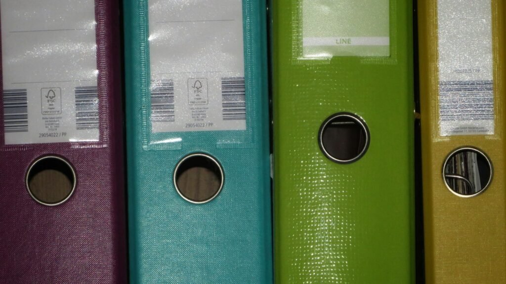 Row of colored binders on a shelf, used to organize medical and case records