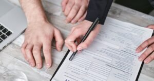 Hands reviewing and signing an insurance policy form during the life insurance contestability period