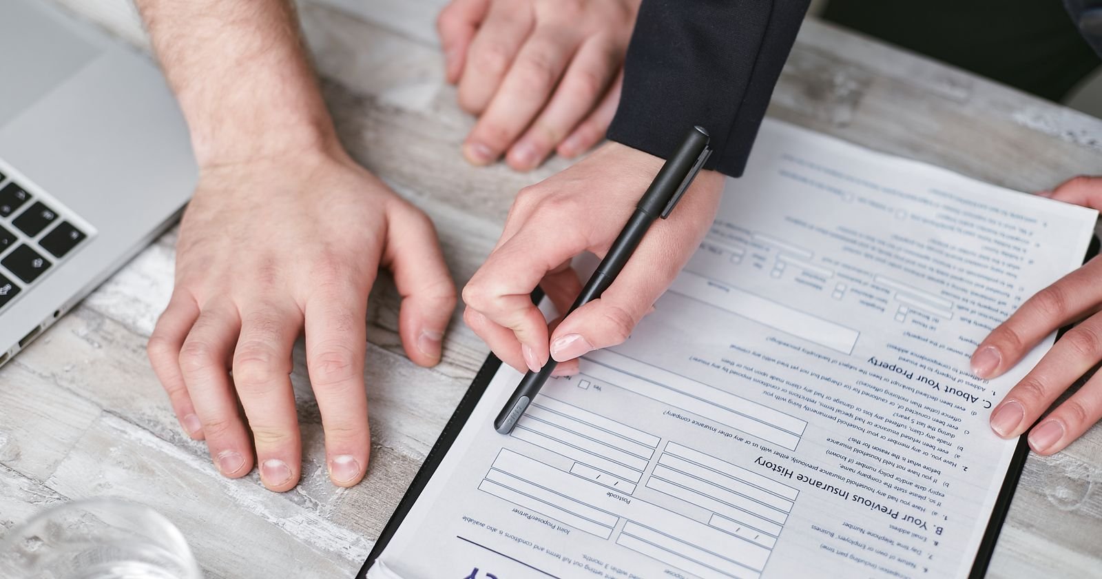 Hands reviewing and signing an insurance policy form during the life insurance contestability period