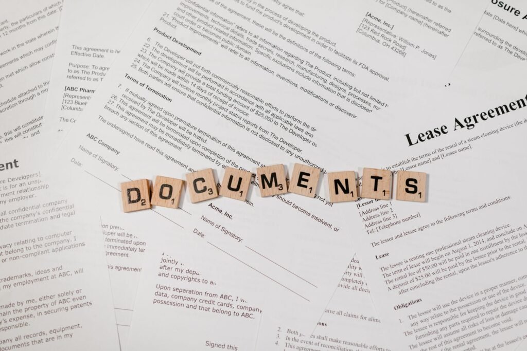 Wooden letter tiles spelling DOCUMENTS on top of contracts and paperwork