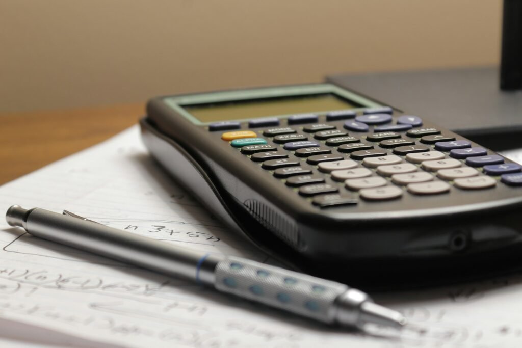 Calculator and pen resting on a sheet of paper, used to total medical bills and lost wages