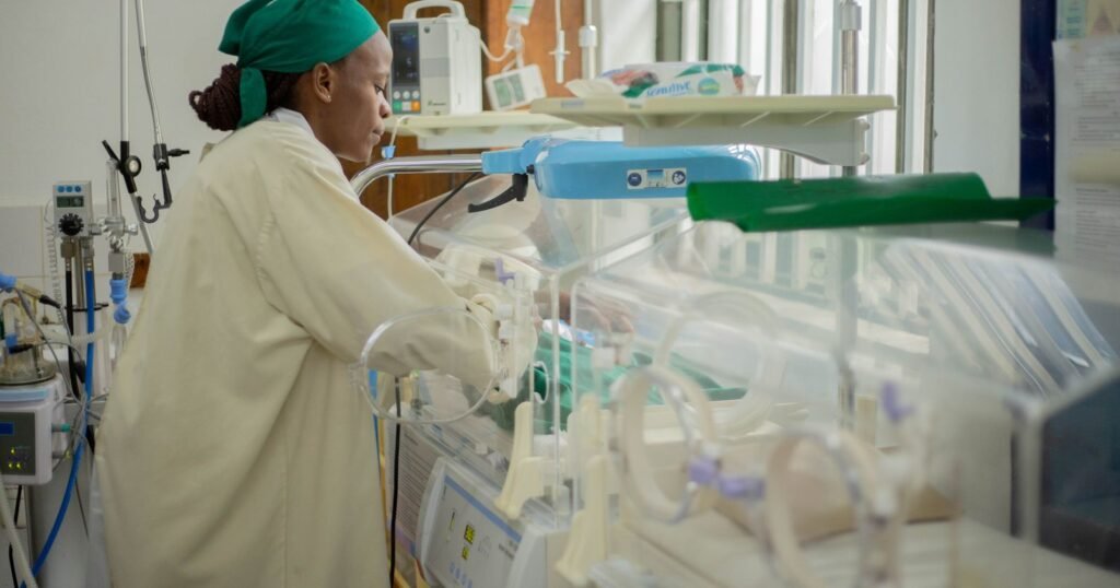 Nurse caring for a newborn in a neonatal intensive care unit, illustrating NEC medical records