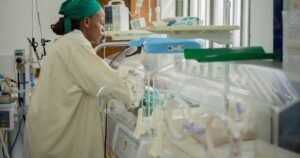 Nurse caring for a newborn in a neonatal intensive care unit, illustrating NEC medical records
