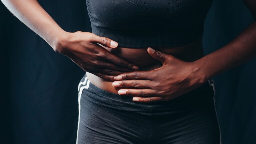 Ozempic gastroparesis lawsuit: person pressing both hands on the stomach, a sign of digestive pain