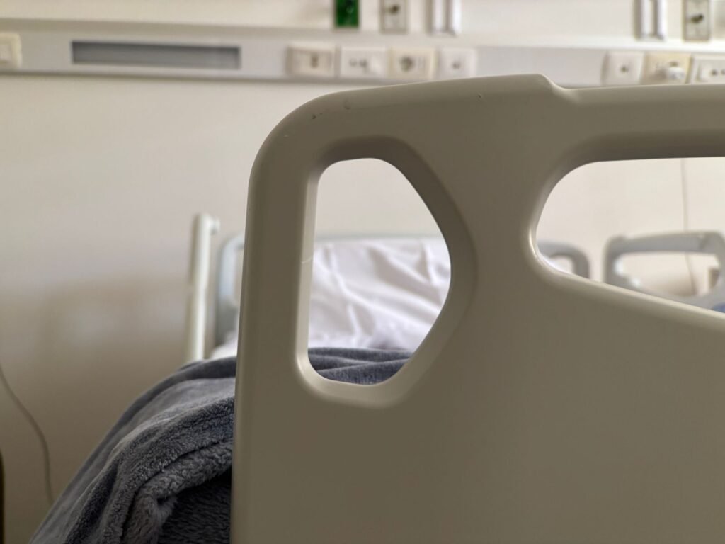 Close-up of an empty hospital bed rail in a quiet hospital room