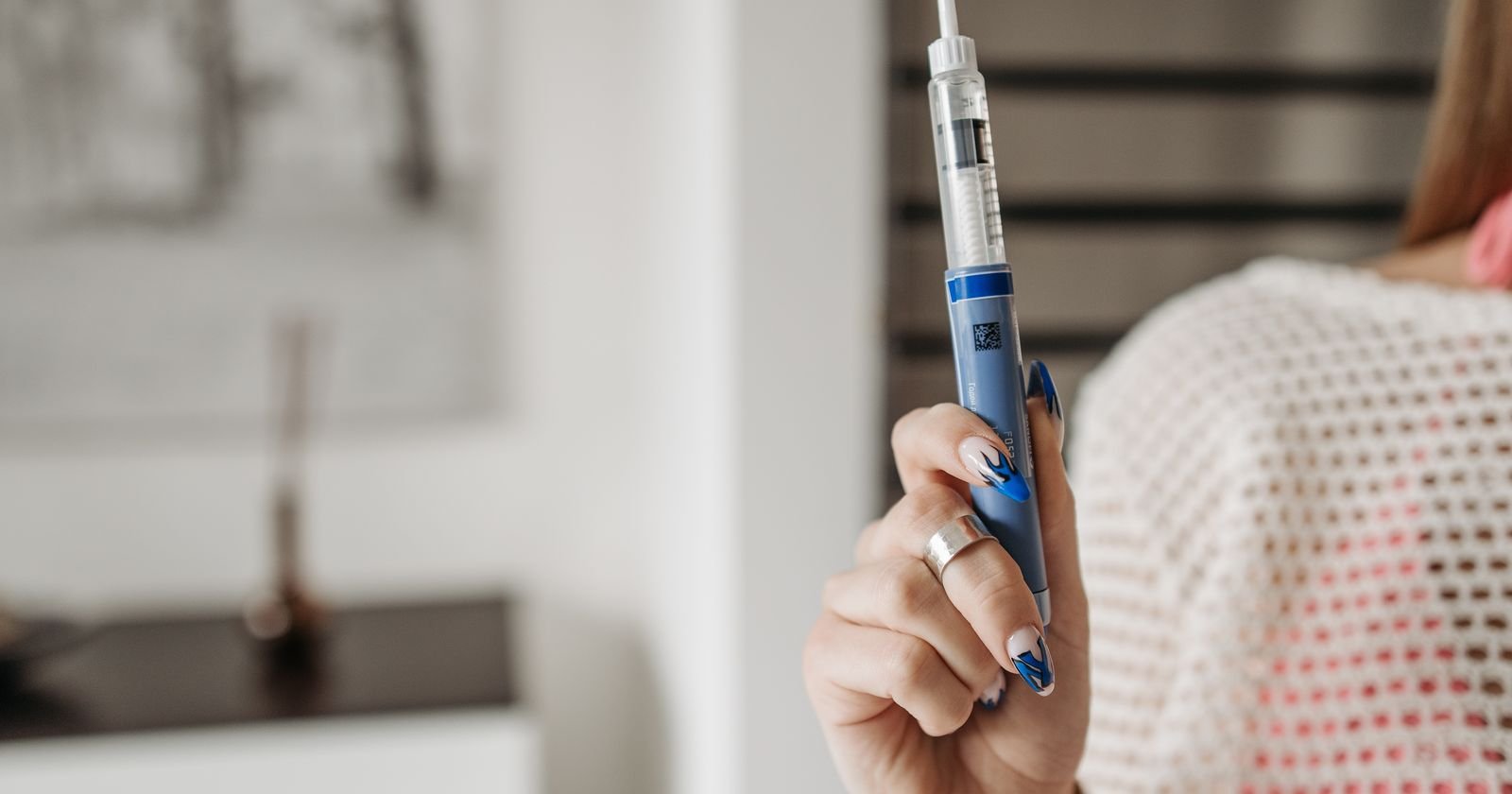 Woman holding a GLP-1 injection pen, illustrating Ozempic lawsuit eligibility