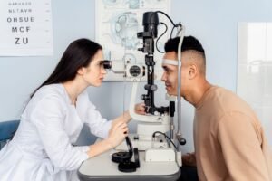 Optometrist examining a patient's eyes with a slit lamp, the kind of exam used to diagnose NAION vision loss