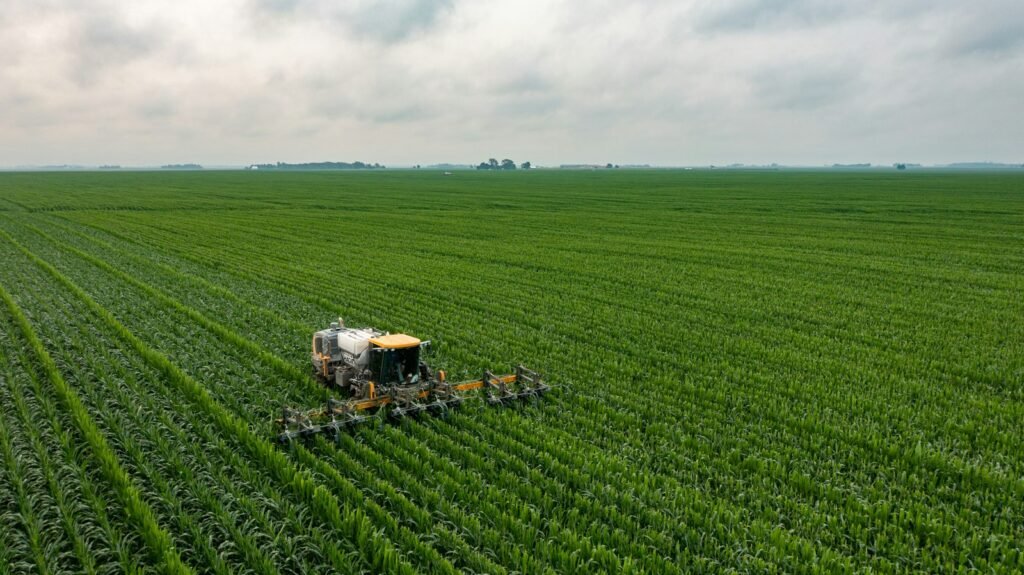 Tractor working a green farm field, the kind of farm work behind many paraquat lawsuit claims