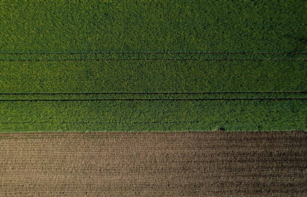 Aerial view of a farm field with a tractor in the middle