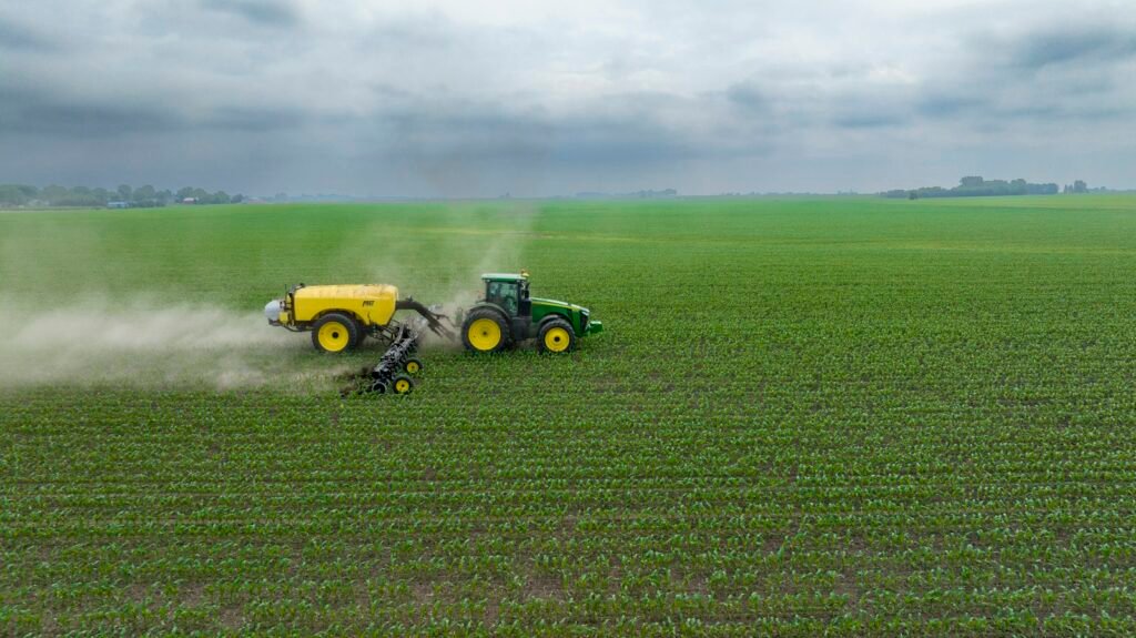 Farm machinery applying treatment across rows of corn, similar to field work described in paraquat lawsuits