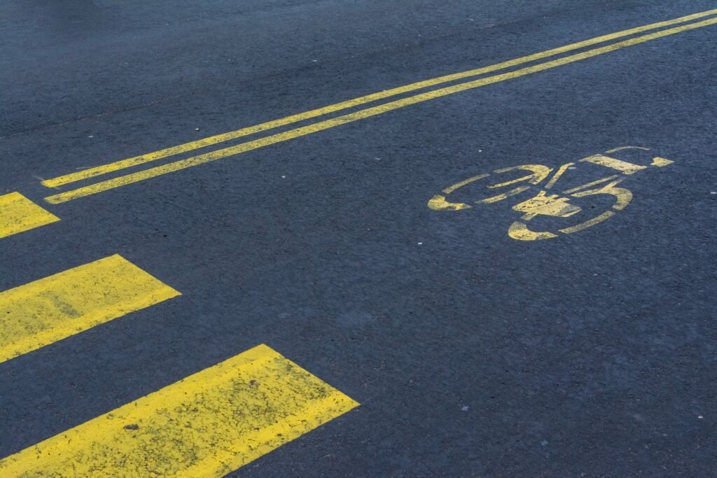 Empty road with a painted yellow bike lane and crosswalk, where a pedestrian or cyclist injury can happen